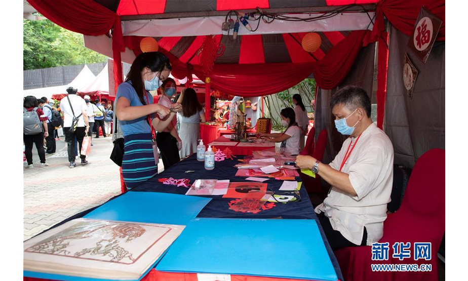 9月26日，在马来西亚吉隆坡附近的马来西亚国家动物园，来宾在“中马文化旅游月·相约大自然”活动上体验剪纸艺术。 由吉隆坡中国文化中心主办的“中马文化旅游月·相约大自然”活动26日在马来西亚国家动物园拉开帷幕，吸引了当地众多市民参与。 新华社记者 朱炜 摄