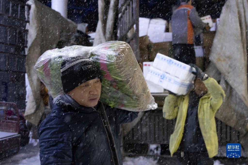 11月22日凌晨，在鸡西市一家大型蔬菜批发市场，工人们在搬运蔬菜。

　　黑龙江省鸡西市气象局于11月22日03时50分将暴雪橙色预警信号升级为暴雪红色预警信号。为保障当地物资运输畅通、居民出行便利，鸡西市相关部门迅速组织除雪力量，一夜无眠的“逆行者”在暴雪中用自己的辛苦付出，保障城市有序运转和居民正常生活。

　　新华社记者 张涛 摄