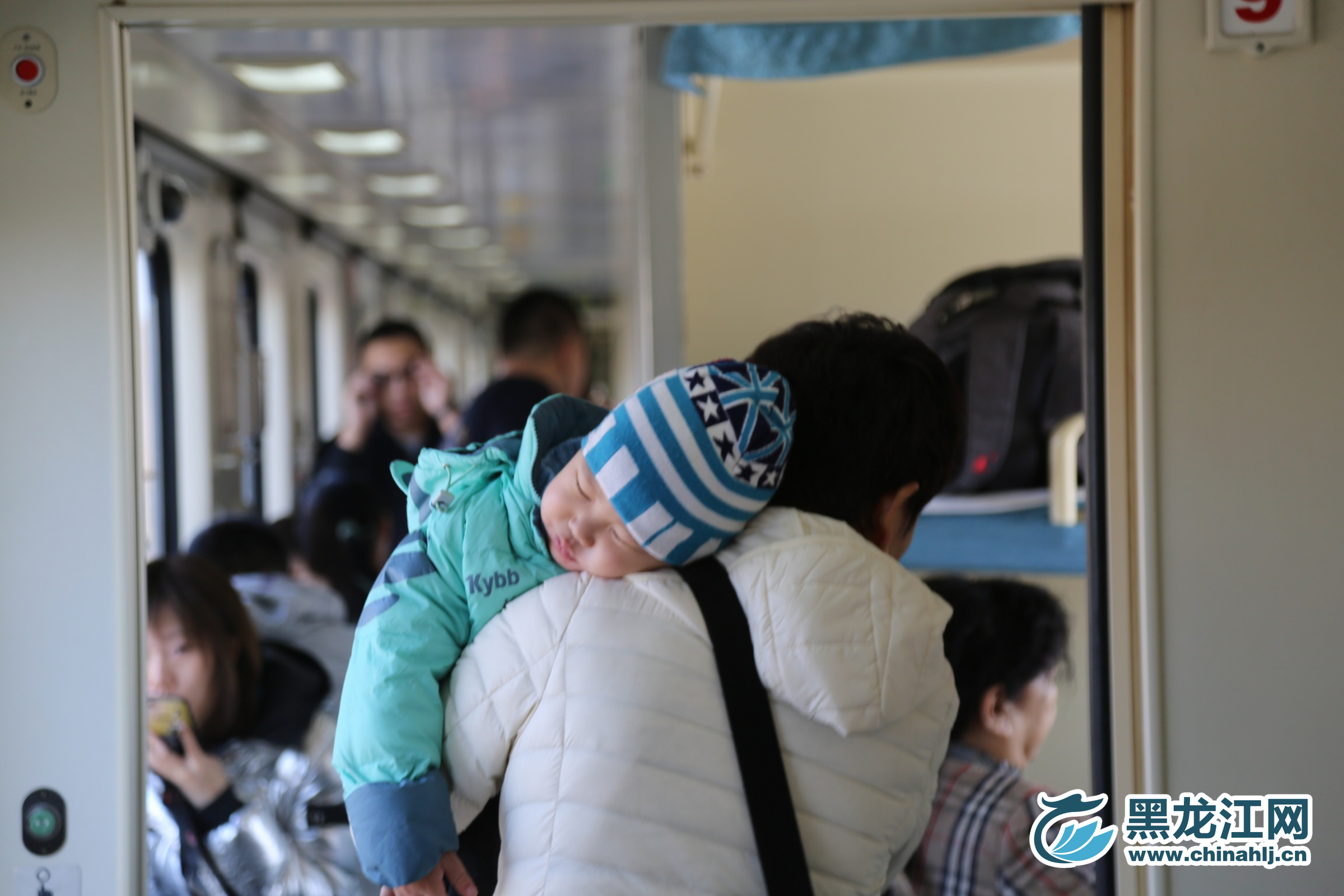 小乘客刚上车就困意来袭，趴在父亲的肩膀上小憩一会。 石启立 摄