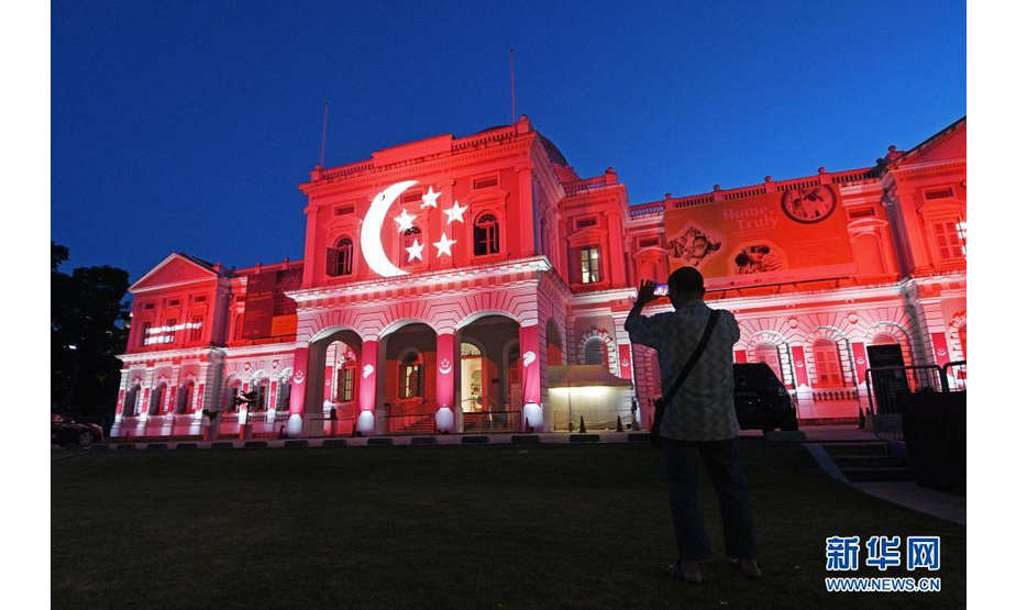 8月10日，一名男子用手机拍摄新加坡国家博物馆庆祝新加坡独立56周年的灯光投影。

　　新华社发 （邓智炜摄）