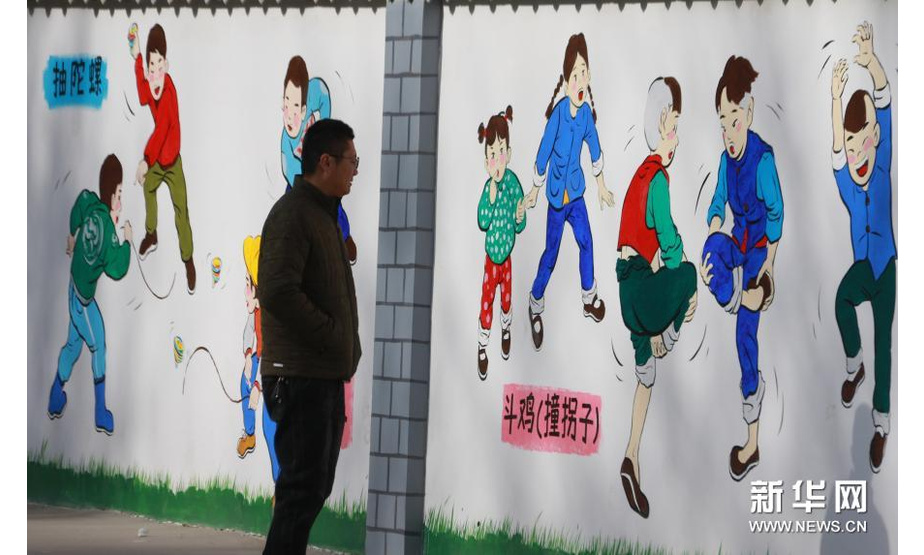 12月5日，市民在敦煌市沙州镇南街社区观看文化墙。新华社发（张晓亮 摄）