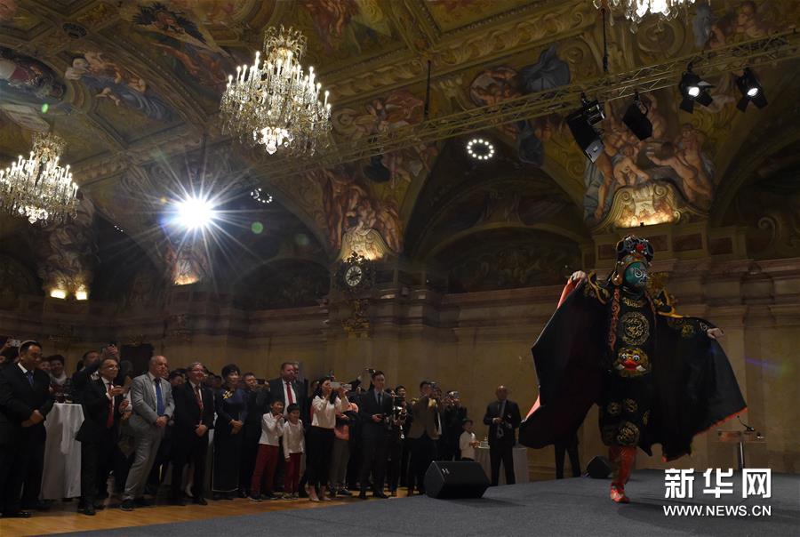 10月9日，在奥地利首都维也纳“文化中国、锦绣四川”四川文化旅游展示会上，人们观看“变脸”表演。新华社记者 郭晨 摄