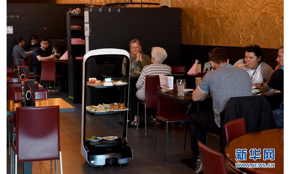 5月28日，在奥地利维也纳一家亚洲餐厅内，机器人给顾客上菜。 维也纳的一家亚洲餐厅于疫情期间重新营业后，更多利用机器人上菜，以减少服务员和顾客之间的非必要接触。 新华社记者 郭晨 摄