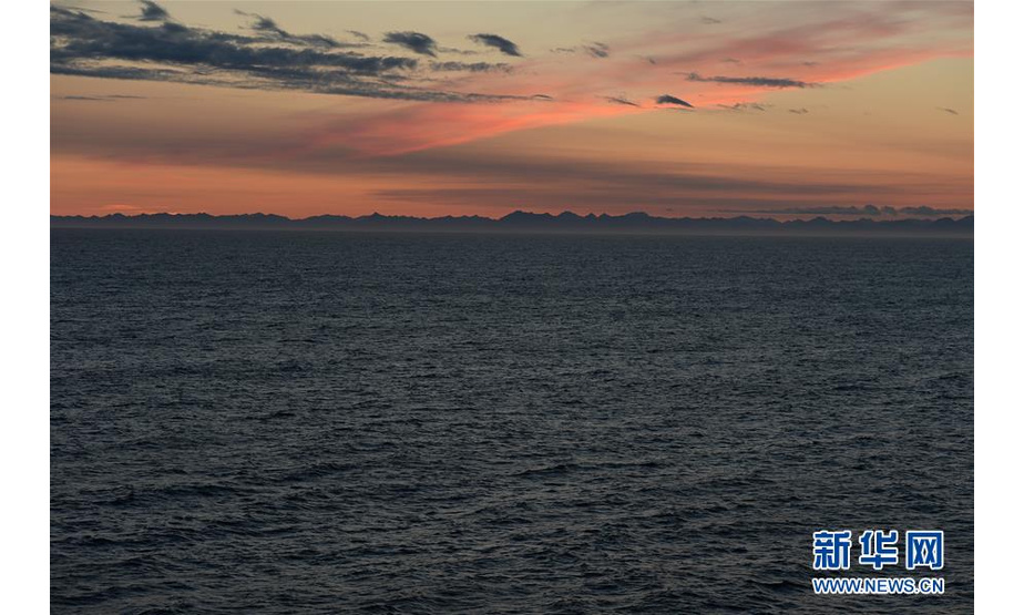 这是8月15日在中远海运“天恩”轮上拍摄的日落，远处为俄罗斯勘察加半岛。新华社记者刘红霞摄
