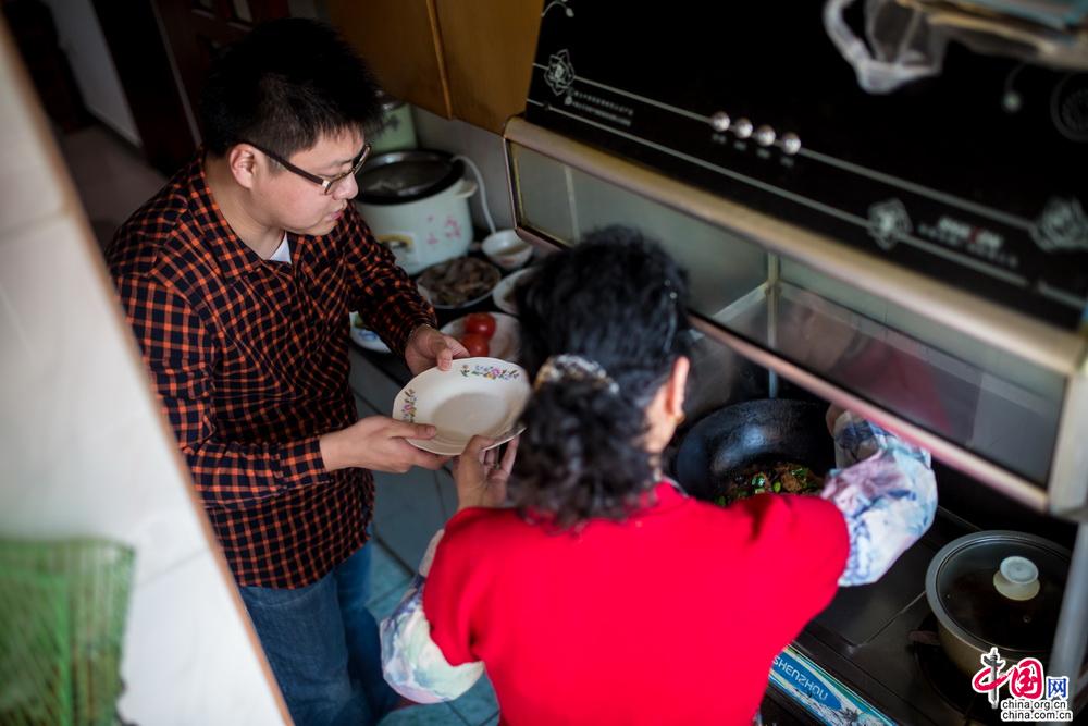 一边和妈妈闲聊一边帮着端盘子、递食材，相比自己的炒菜时的手忙脚乱，妈妈确实强大的太多了。看着那些熟悉的味道一盘盘从锅里被盛出来，想到平时总是妈妈一个人在窄窄的厨房里忙碌，瞬间，觉得自己太不孝顺…中国网记者 郑亮 摄