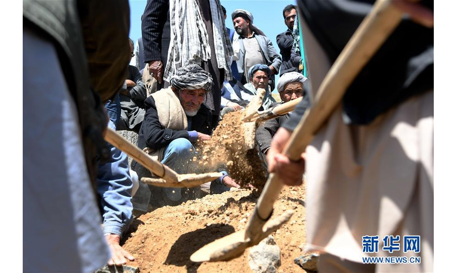 4月23日，在阿富汗首都喀布尔郊外的一处公共墓地，人们安葬逝去的亲友。新华社记者代贺摄