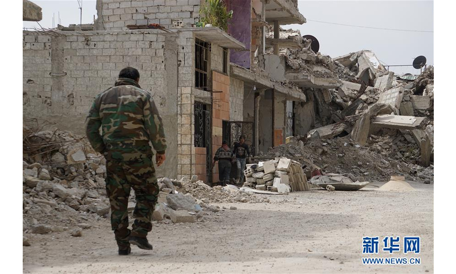 3月12日，在叙利亚大马士革东古塔地区，一名士兵走过一栋正在整修的民居。 新华社记者汪健摄