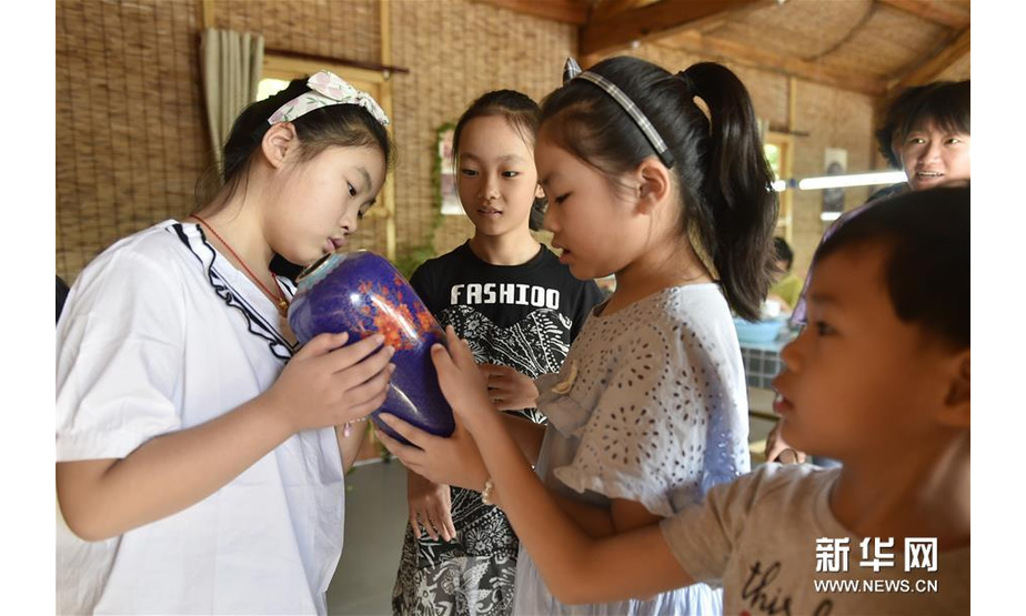 8月25日，孩子们在香河县北李庄村的乡村旅游非遗体验园里观摩景泰蓝制品。新华社记者 鲁鹏 摄