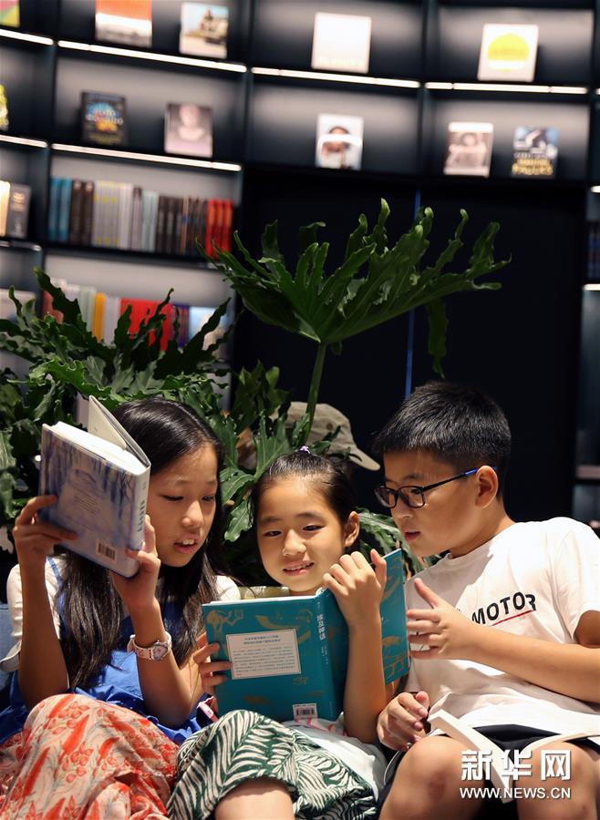 8月12日，读者在朵云书院内读书。 当日，位于上海中心大厦52层的朵云书院正式开业。在离地239米的空中、2000多平方米的空间内，朵云书院售卖16000多种、6万多册中外书籍。书店集阅读、艺术展览、品牌文创、社交休闲等多功能于一体，拥有独特的空中视野和“抬头看云、低头看书”的阅读环境。 新华社记者 刘颖 摄