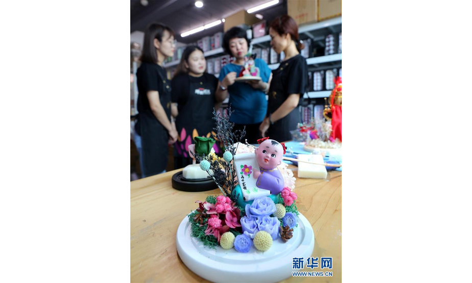 8月19日，在石家庄市“那些花儿”创意工作室，李虹与工作人员讨论“永生花”创意作品。新华社记者 赵丹惠 摄