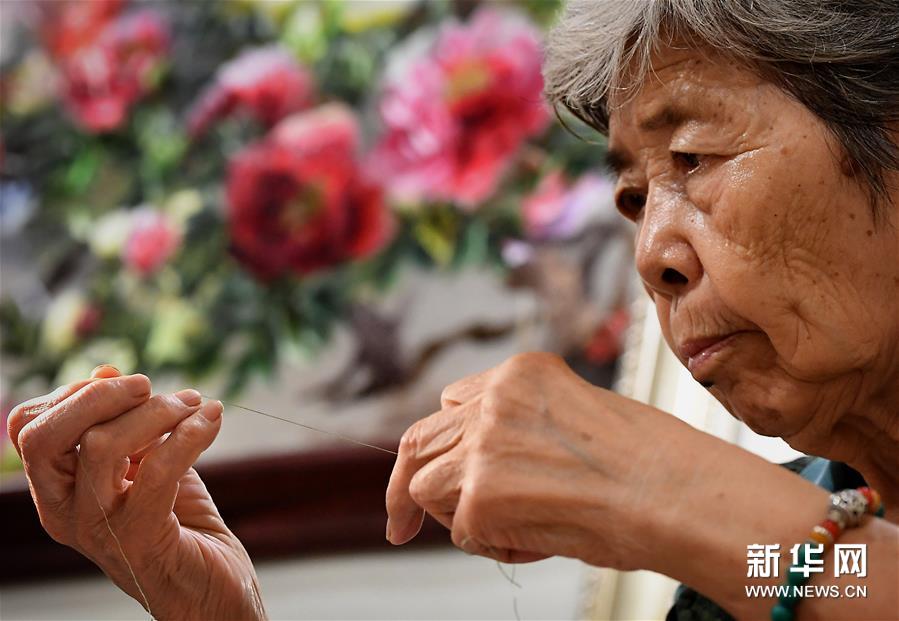 在开封市素花宋绣工艺有限公司的展示馆里，王素花在劈线（7月30日摄）。新华社记者李安摄