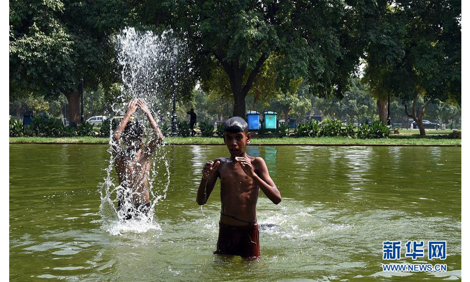 6月7日，在印度首都新德里，两名男孩在水池内玩耍。 自印度国家气象局2日发布高温预警以来，印度多地持续高温天气。 新华社记者张迺杰摄