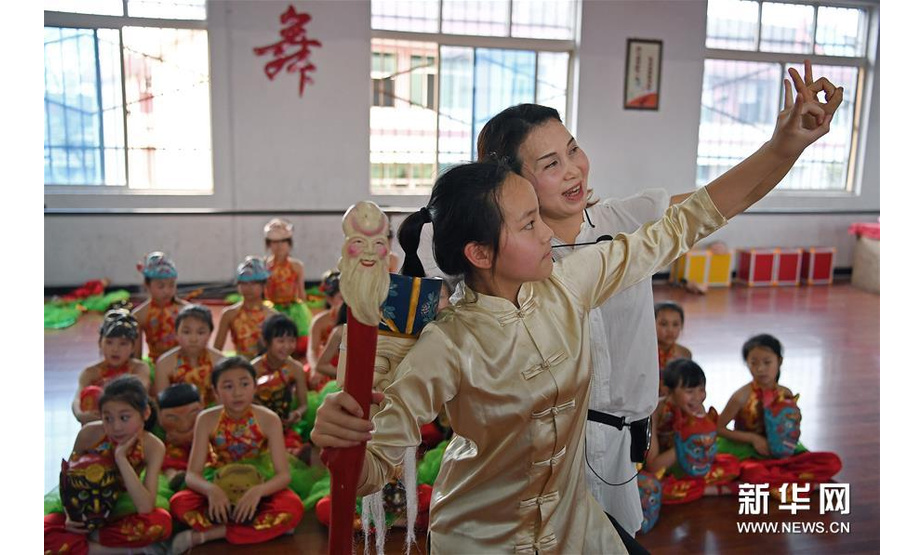 4月23日，在江西省南丰县教师进修学校附属小学，指导老师给孩子们示范傩舞的动作。 新华社记者 万象 