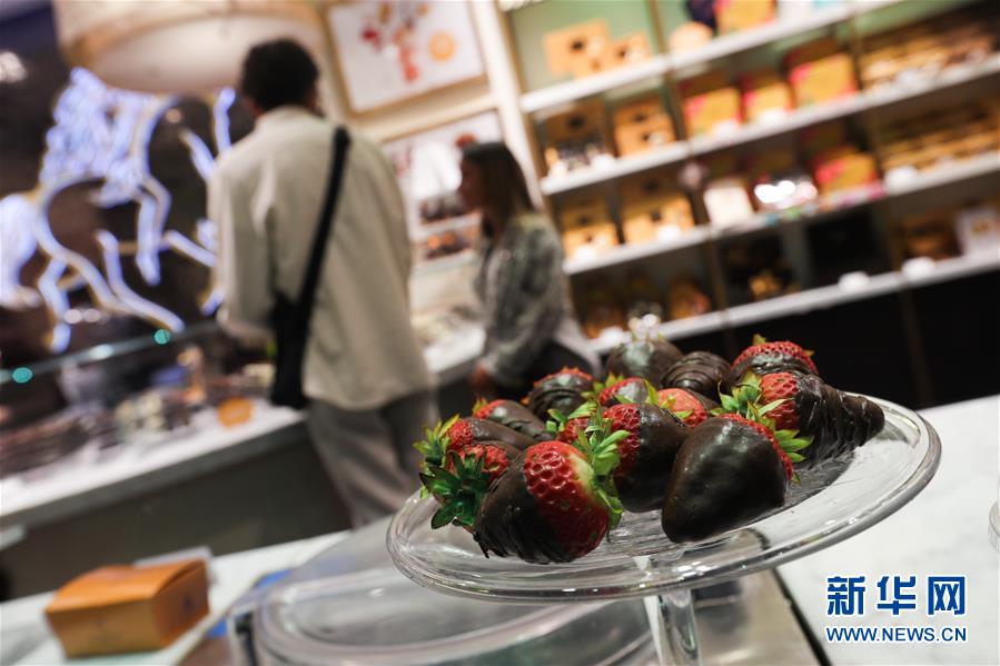 8月19日，顾客在比利时布鲁塞尔一家巧克力店选购巧克力甜品。 巧克力是比利时最具代表性的甜品，与钻石和啤酒并称比利时三大“国宝”。比利时巧克力拥有细腻的结构、高可可含量、美妙的口感和极富创意的造型，这份浓情蜜意从比利时出口至世界各地，受到全世界消费者的喜爱。 新华社记者 郑焕松 摄