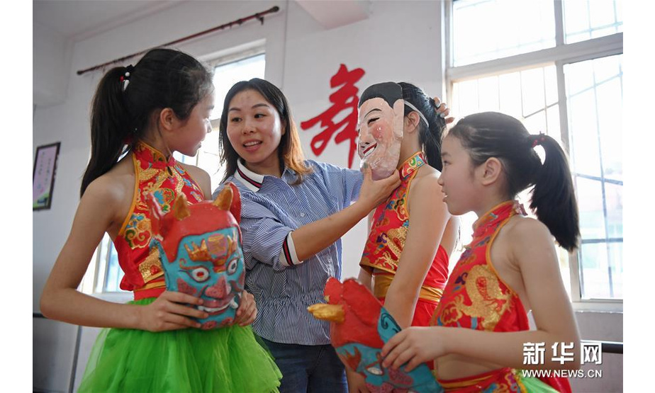 4月23日，在江西省南丰县教师进修学校附属小学，指导老师给孩子们讲解傩面具的历史故事。 新华社记者 万象 摄