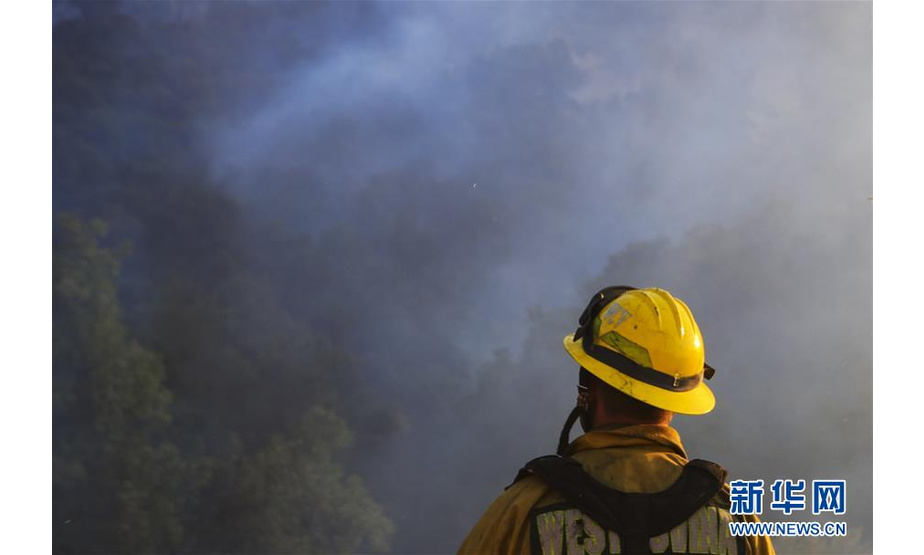 10月12日，在美国加利福尼亚州西尔马，消防员在山火现场执勤。新华社记者 李颖 摄