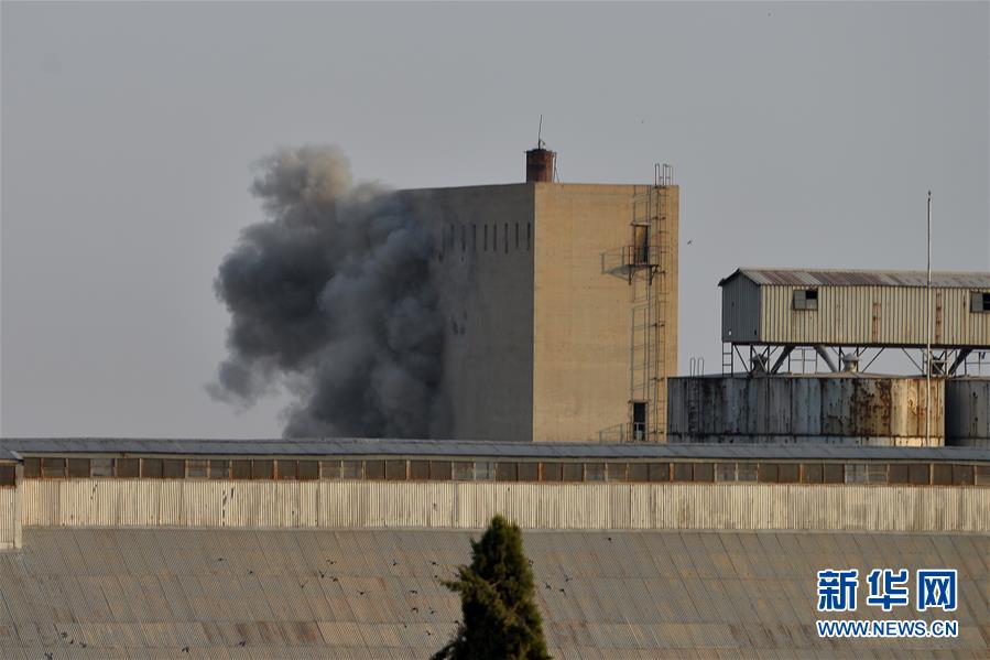 这是10月9日在土耳其边境的杰伊兰珀纳尔附近拍摄的遭到土军炮击的叙利亚拉斯艾因市。新华社发（穆斯塔法·卡亚摄）