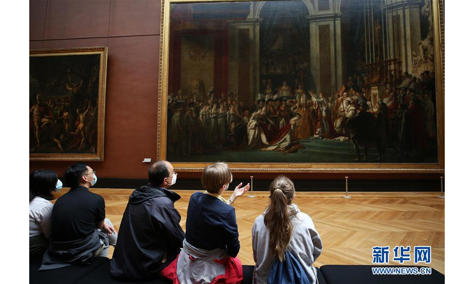 7月6日，参观者在法国巴黎卢浮宫博物馆欣赏画作《拿破仑加冕》。 因新冠病毒疫情关闭3个多月后，法国卢浮宫博物馆于6日重新开放。 新华社记者 高静 摄