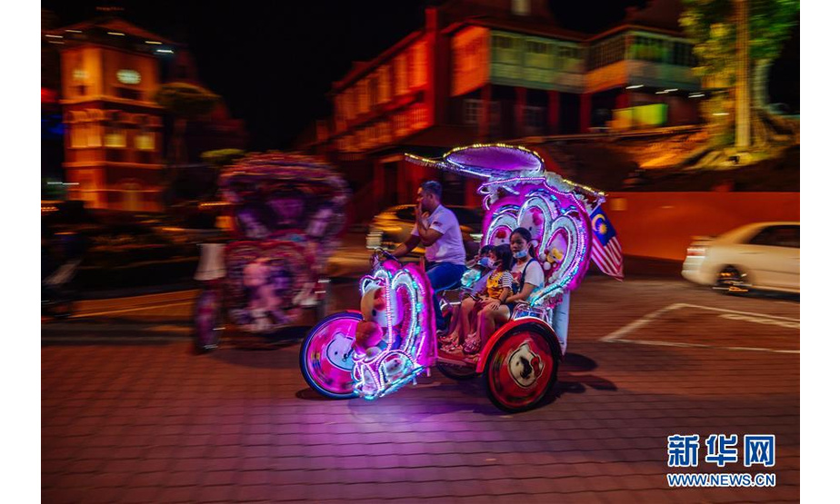 这是2020年9月18日，在马来西亚马六甲，游客乘坐花车游览。  新华社记者 朱炜 摄