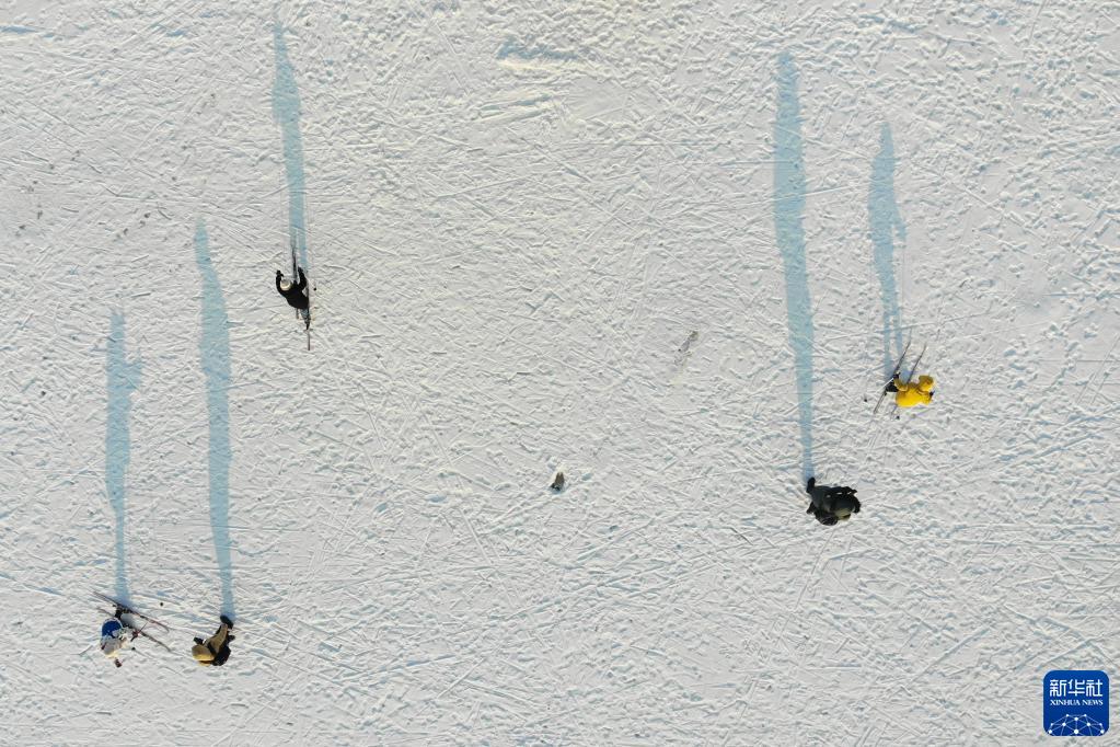 随着北京冬奥会临近，中国最北省份黑龙江省的冰雪运动氛围渐浓，越来越多人在这片广阔的黑土地走上冰场、雪道，化身“冰雪健将”，享受冰情雪趣。

　　从举办第一届全国冰上运动会到获得中国首个冬季运动项目世界冠军，再到每年带动千万人次参与冰雪运动……作为我国开展冰雪运动最早的省份之一，黑龙江不断推进冰雪体育发展，助力北京冬奥会，推动全民上冰雪。

　　迄今为止，在我国获得的13枚冬奥会金牌中，有8枚是由黑龙江培养、输送的运动员所获得，还有1枚短道速滑接力金牌，队中主力王濛即是黑龙江人。黑龙江省连续开展40余年的“百万青少年上冰雪”活动，激发了一代代青少年的冰雪运动热情，更为我国冰雪体育运动发展培养了大批后备人才。

　　图为滑雪爱好者在冰封的江面上体验滑雪（1月23日摄，无人机照片）。

　　新华社记者 张涛 摄