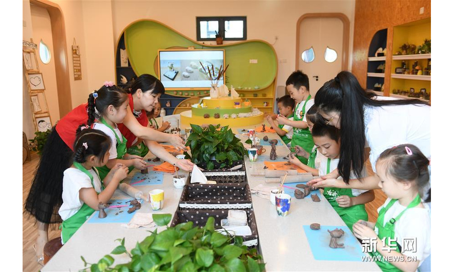 8月19日，陶艺老师和党员志愿者带着小朋友进行陶艺创作。新华社记者翁忻旸摄