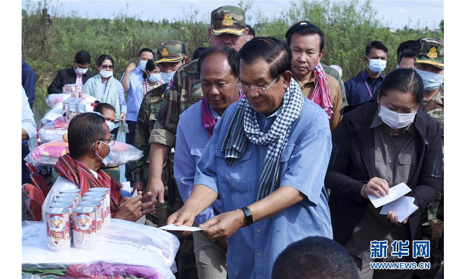 10月21日，在柬埔寨班迭棉吉省，柬埔寨首相洪森（中）向受灾群众发放慰问品。 柬埔寨首相洪森21日在柬西北部班迭棉吉省表示，近期洪灾已导致柬34人丧生。柬埔寨国家灾难管理委员会19日说，雨季暴雨加上热带风暴带来的洪灾已影响到柬19个省和直辖市，逾31万人受灾，超过7.3万栋房屋、29万公顷农田被淹，政府已出动军队等开展抗洪救灾、帮助民众撤离，已有3.7万余人被疏散。 新华社发（李莱 摄）