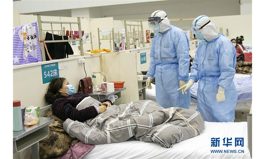 2月10日，在武汉客厅方舱医院，医护人员在询问患者病情。 武汉方舱医院从2月5日收治首批患者以来，运行平稳有序，患者在医护人员的精心照顾下调养身体，等待痊愈。 新华社记者 熊琦 摄