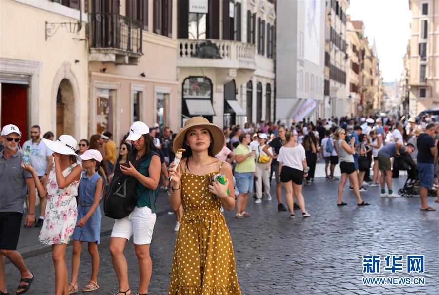 8月12日，在意大利首都罗马，一名女子在西班牙广场吃冰淇淋消暑。 当日，罗马最高气温达到37摄氏度，体感温度更是一度突破40摄氏度。 新华社记者程婷婷摄