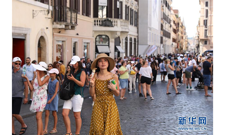 8月12日，在意大利首都罗马，一名女子在西班牙广场吃冰淇淋消暑。 当日，罗马最高气温达到37摄氏度，体感温度更是一度突破40摄氏度。 新华社记者程婷婷摄