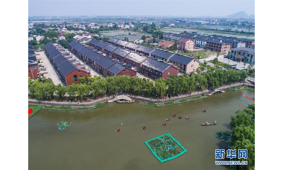 6月5日，村民们在泉益村滨水公园的河道内参加端午划菱桶趣味比赛（无人机拍摄）。 新华社记者 徐昱 摄