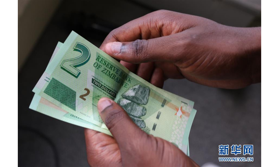 11月12日，在津巴布韦首都哈拉雷，一名民众手持面值2元的新津元纸币。 津巴布韦储备银行（央行）11日开始发行新的本国货币新津巴布韦元，从而结束了该国10年没有本币的局面。 新华社发（肖恩·朱萨 摄）