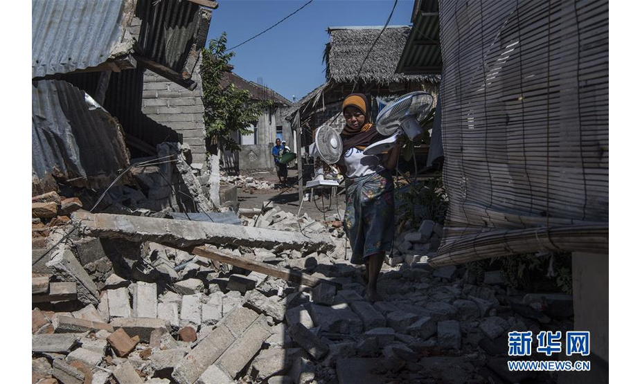 8月8日，在印度尼西亚龙目岛地震灾区，灾民在倒塌的房屋中收拾物品。 新华社记者吕小炜摄