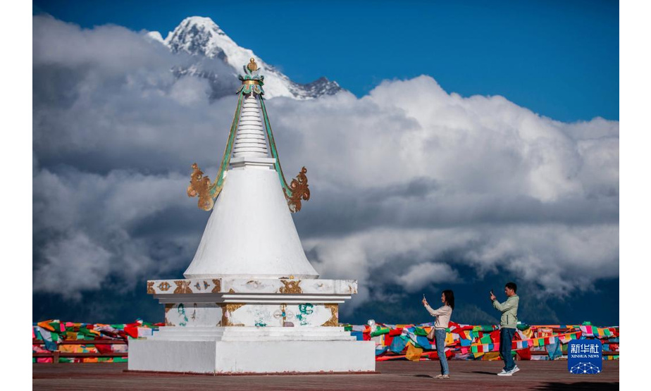 9月15日，游客在梅里雪山前拍摄留念。

　　初秋时节，云南迪庆藏族自治州的梅里雪山与云海交相辉映，景色迷人。

　　新华社记者胡超 摄
