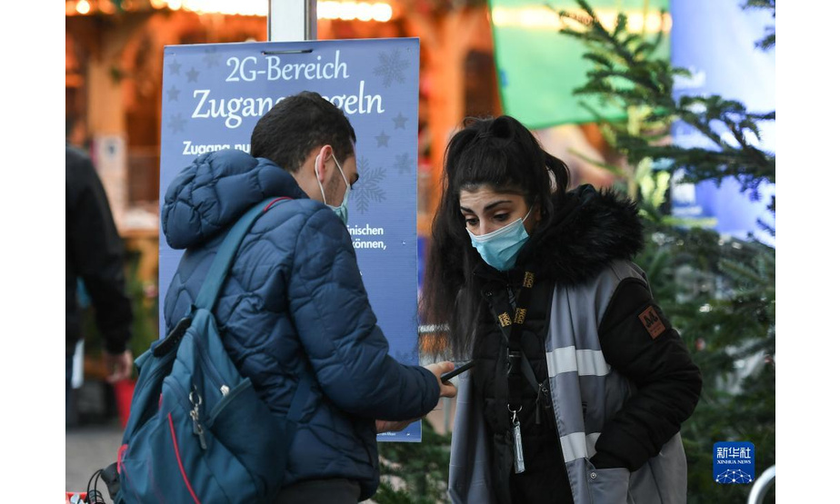 11月22日，在德国法兰克福圣诞市场外，一名工作人员检查市民的健康通行证。

　　受新冠疫情影响，德国柏林、法兰克福等地的圣诞市场有的取消，有的在较为严格的防疫措施下开放。

　　新华社记者 逯阳 摄
