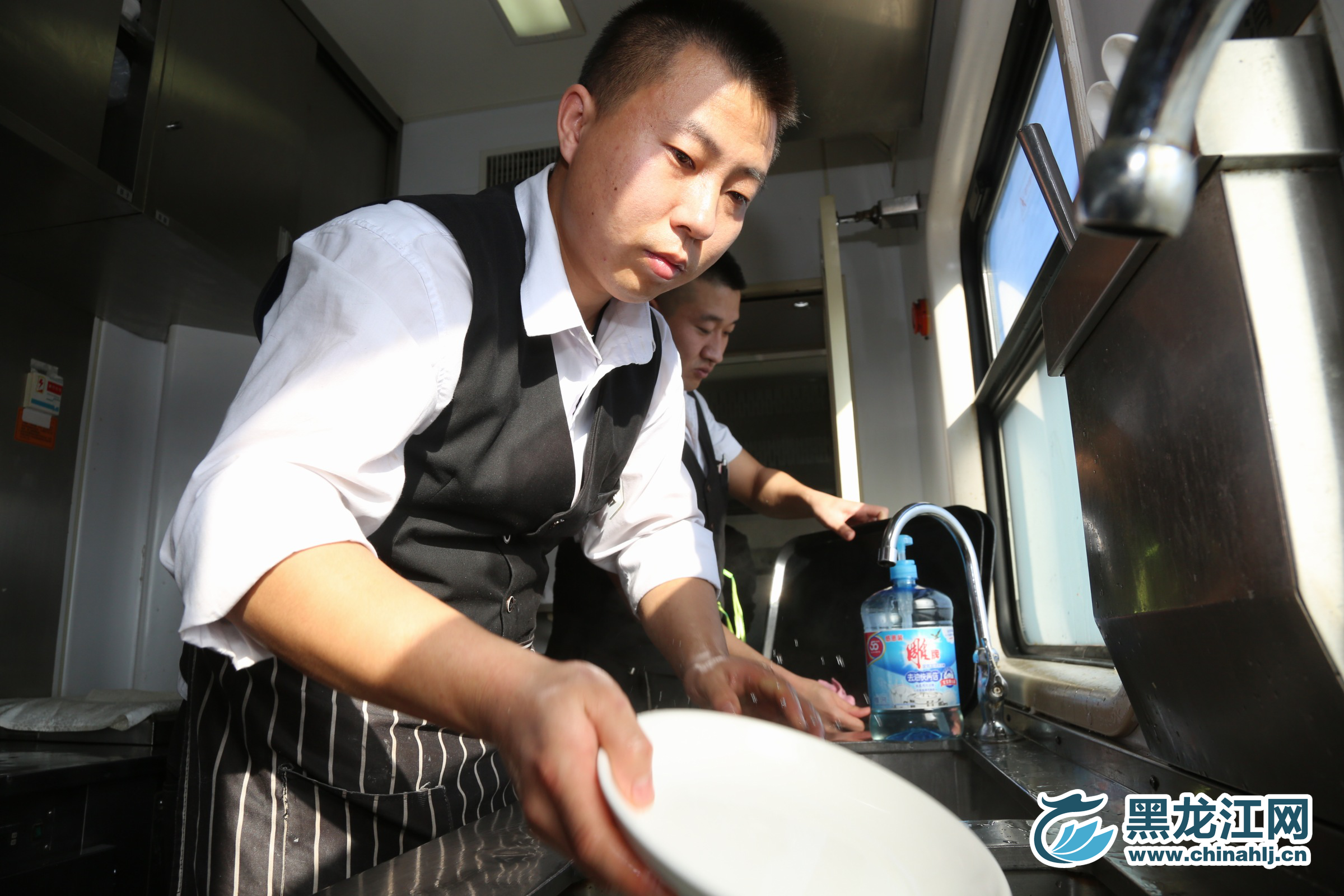 图为师傅在清洗餐具。石启立 摄