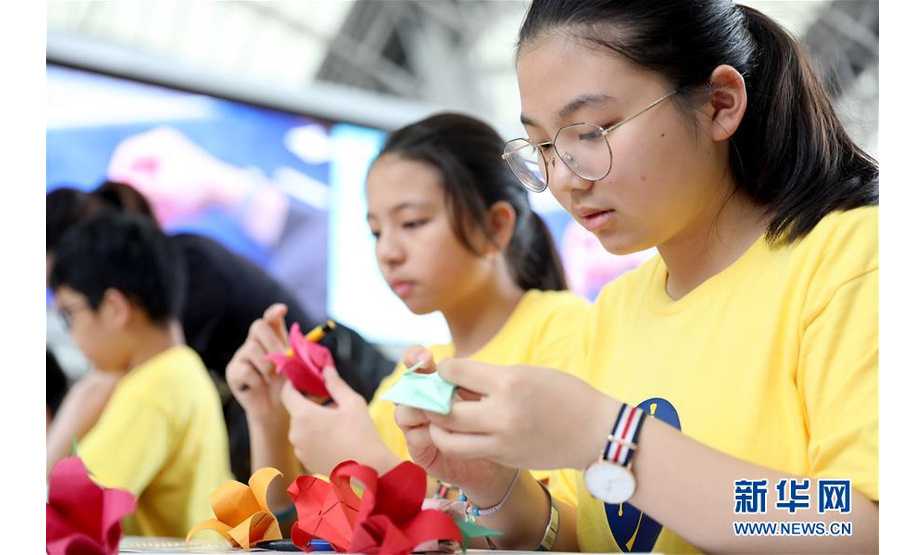 4月19日，学生在活动现场折纸。当日，香港多所中小学和社会团体的上千名成员参加一场名为“同心创世界纪录”的活动，在一名折纸艺术家带领下刷新“最大规模折纸课”的吉尼斯世界纪录。新华社记者 吴晓初 摄
