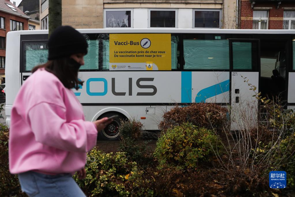 11月30日，一名女子经过比利时布鲁塞尔的一辆新冠疫苗接种巴士。

　　新冠病毒奥密克戎变异株正在全球引发高度关注。世界卫生组织11月29日说，新冠变异病毒奥密克戎毒株在全球范围造成感染病例激增的风险“非常高”，并可能给部分地区带来“严重后果”。目前，多个国家和地区陆续通报发现奥密克戎毒株感染或疑似病例。新华社记者 郑焕松 摄