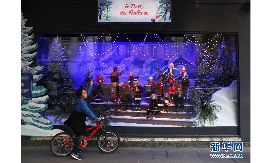 11月22日，一名男孩在法国巴黎老佛爷百货商店的圣诞橱窗前驻足欣赏。新华社记者 高静 摄