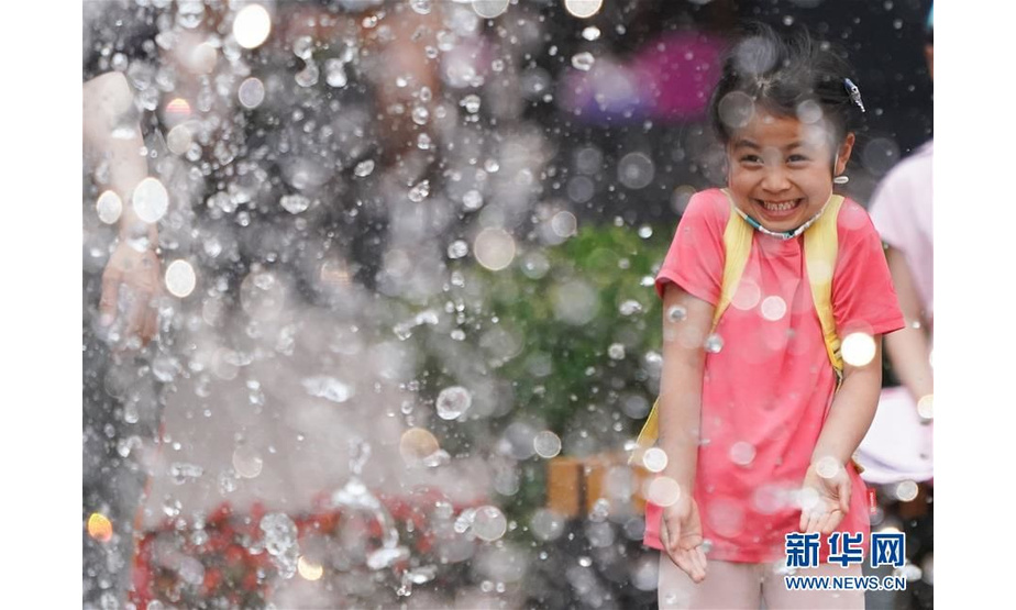 北京王府井步行街，小朋友在喷泉前玩耍（5月29日摄）。 新华社记者鞠焕宗摄