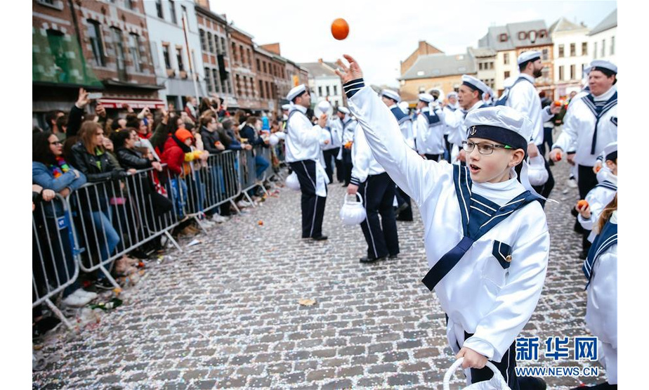 3月5日，在比利时南部小镇班什，当地居民装扮成“水手”形象，一边游行一边向游客扔血橙。据说，血橙代表祝福，接到或被扔到的人都会交好运。 当日是2019年比利时班什狂欢节的最后一天，也是高潮部分。起源于中世纪的班什狂欢节寓意辞旧迎新，并于2003年11月被列入联合国教科文组织非物质文化遗产名录。班什当地居民打扮成“憨人”“水手”“农夫”“小丑”等形象，和游客一起参与狂欢。“憨人”是吉祥与快乐的代言人，也是班什狂欢节最具标志性的形象。 新华社记者 张铖 摄
