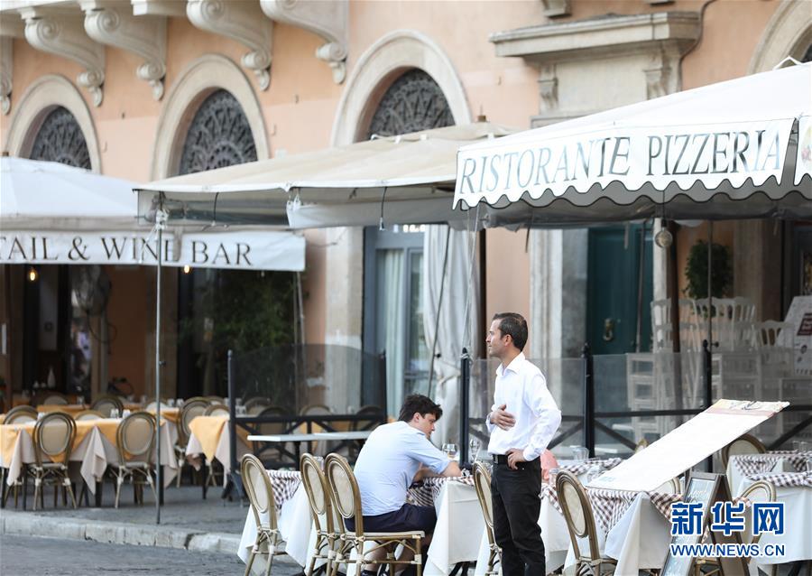 8月4日，在意大利首都罗马，一家餐厅的工作人员站在门口招揽顾客。 受新冠疫情影响，今年夏天罗马的历史中心区游客比往年明显减少。 新华社记者 程婷婷 摄