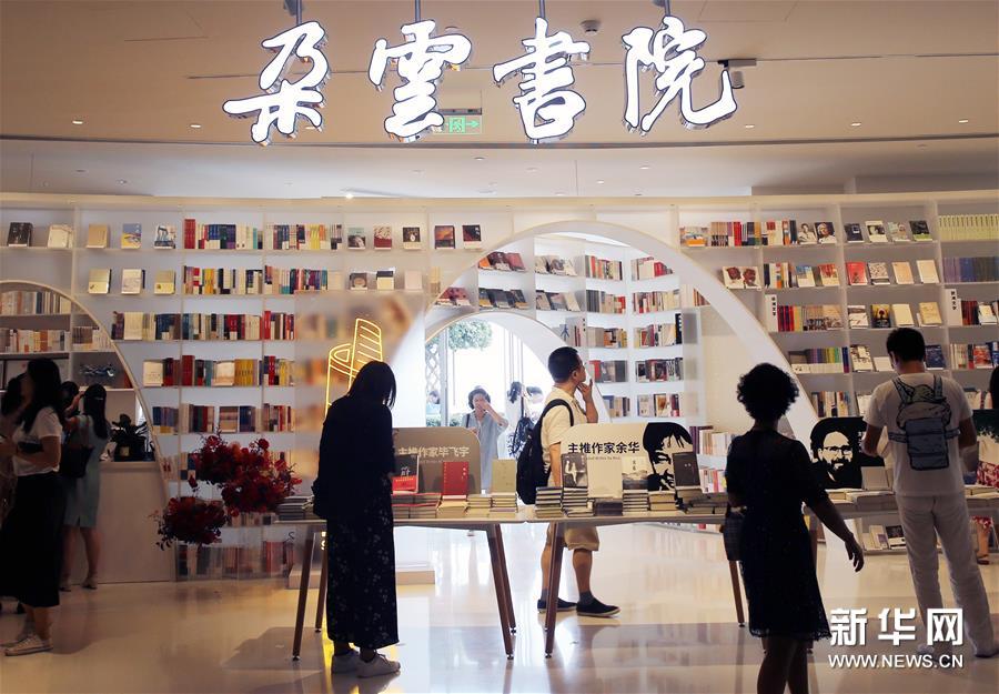 8月12日，顾客在朵云书院内参观选购。 当日，位于上海中心大厦52层的朵云书院正式开业。在离地239米的空中、2000多平方米的空间内，朵云书院售卖16000多种、6万多册中外书籍。书店集阅读、艺术展览、品牌文创、社交休闲等多功能于一体，拥有独特的空中视野和“抬头看云、低头看书”的阅读环境。 新华社记者 刘颖 摄