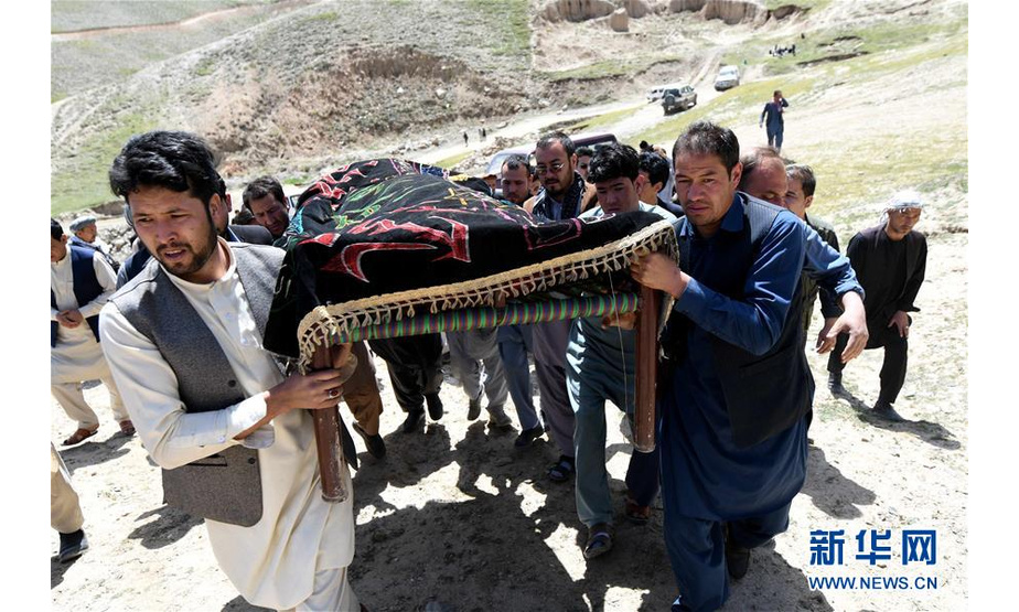 4月23日，在阿富汗首都喀布尔郊外的一处公共墓地，一名男子（前左）抬着妻子的棺材。新华社记者代贺摄