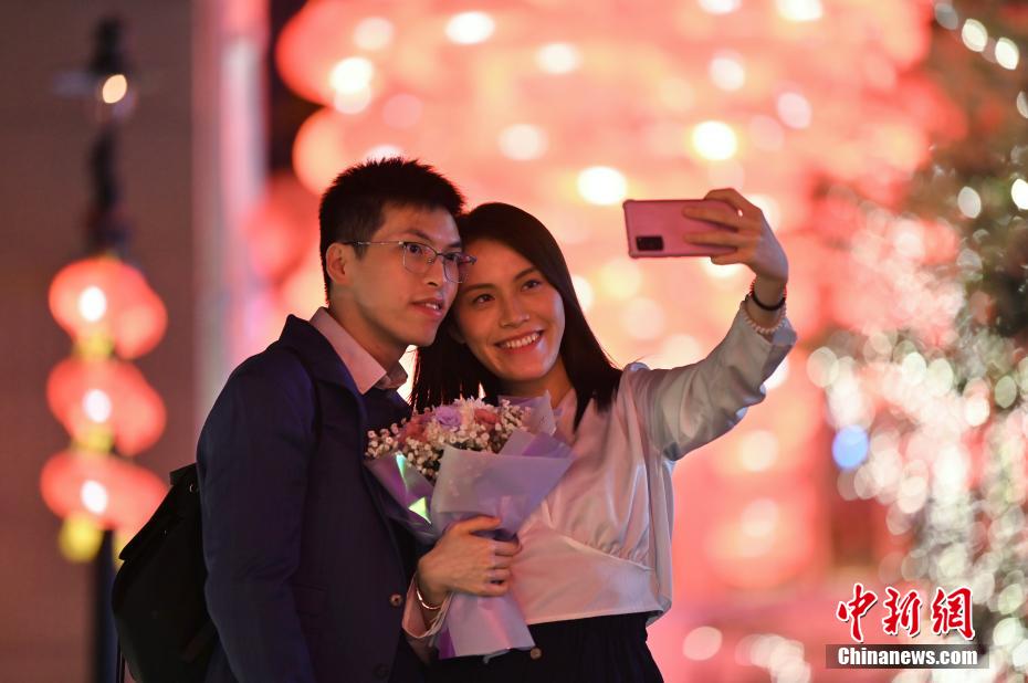 情侣于大红灯笼下享受浪漫时光。 李志华 摄