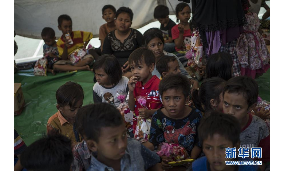 8月8日，在印度尼西亚龙目岛地震灾区，灾民等待领取救援物资。  新华社记者吕小炜摄