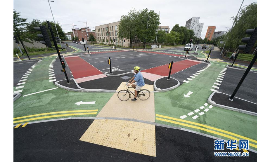7月9日，在英国曼彻斯特，市民骑车在自行车道通行。新华社发（乔恩·休珀摄）