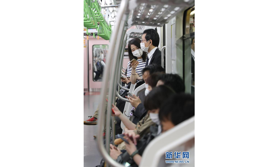 5月25日，在日本东京，乘客戴着口罩乘坐电车。 日本首相安倍晋三25日晚宣布，日本全国解除紧急状态。此前日本47个都道府县中已仅剩东京都、北海道等5个维持紧急状态。 新华社记者 杜潇逸 摄