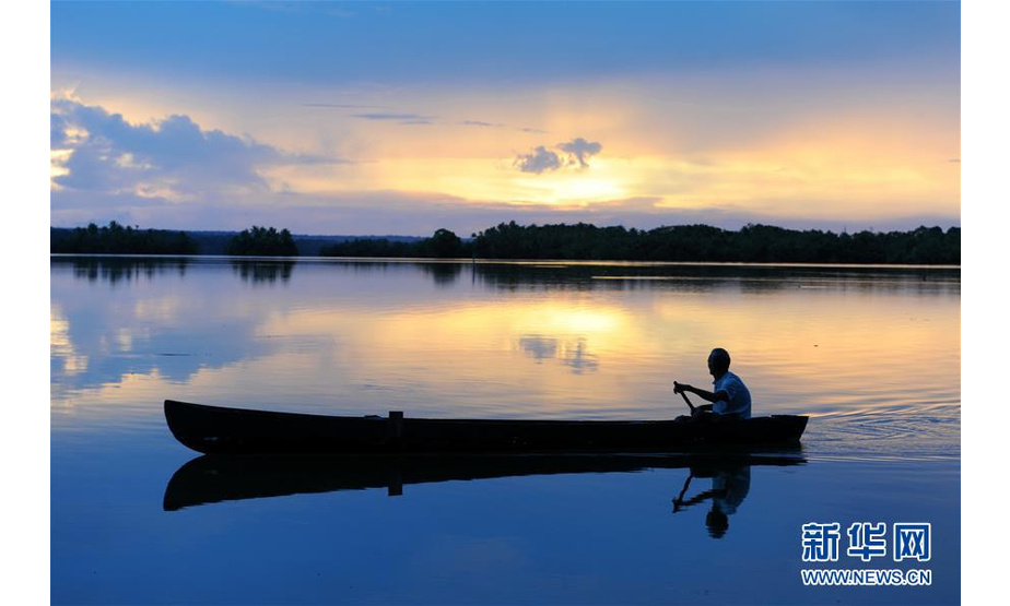 2013年10月30日，在所罗门群岛的东伦内尔岛，一名男子在黎明时分泛舟特加诺湖。 新华社记者高健钧摄