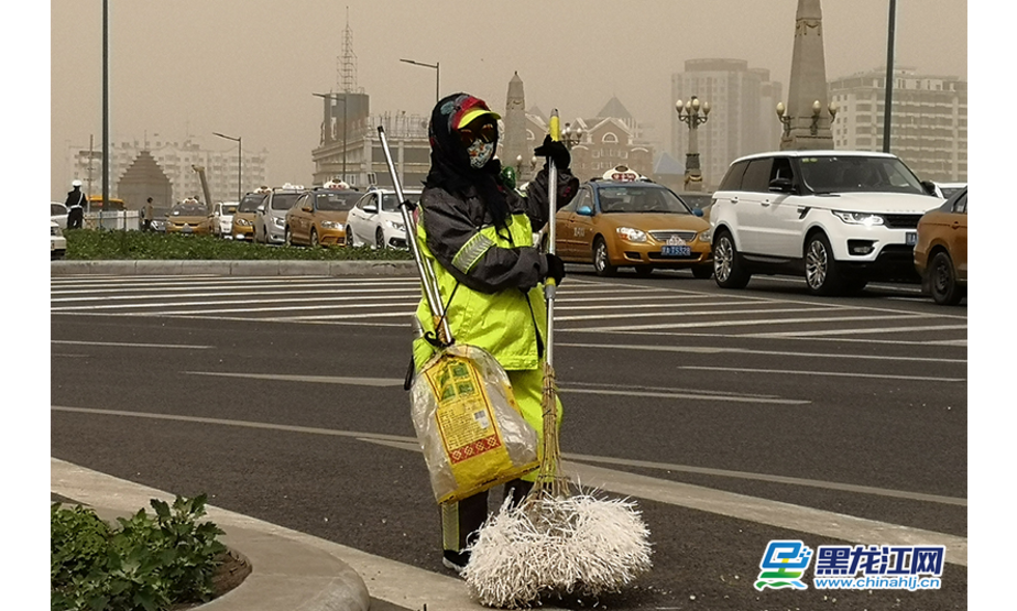 路边，环卫工人带着口罩正在清扫垃圾。王忠岩 摄