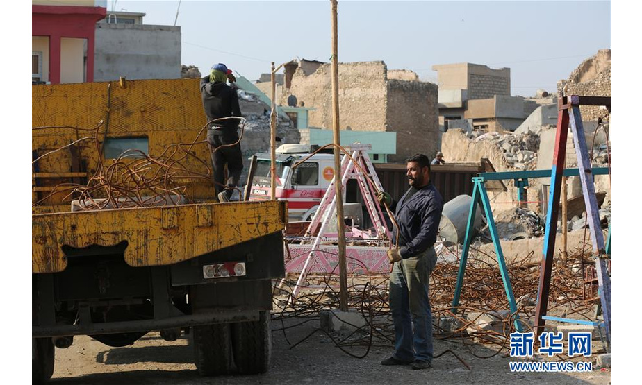 12月4日，在伊拉克摩苏尔老城，工人在废墟上开展重建。 新华社发（哈利勒·达伍德摄）